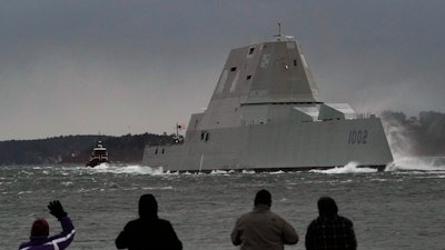 Spectators watch the USS Lyndon B. Johnson Zumwalt-class destroyer travel down the Kennebec River on its way to sea Jan. 12, 2022, in Phippsburg, Maine.