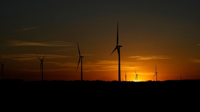 The sun sets behind a wind farm near Del Rio, Texas, Wednesday, Feb. 15, 2023.