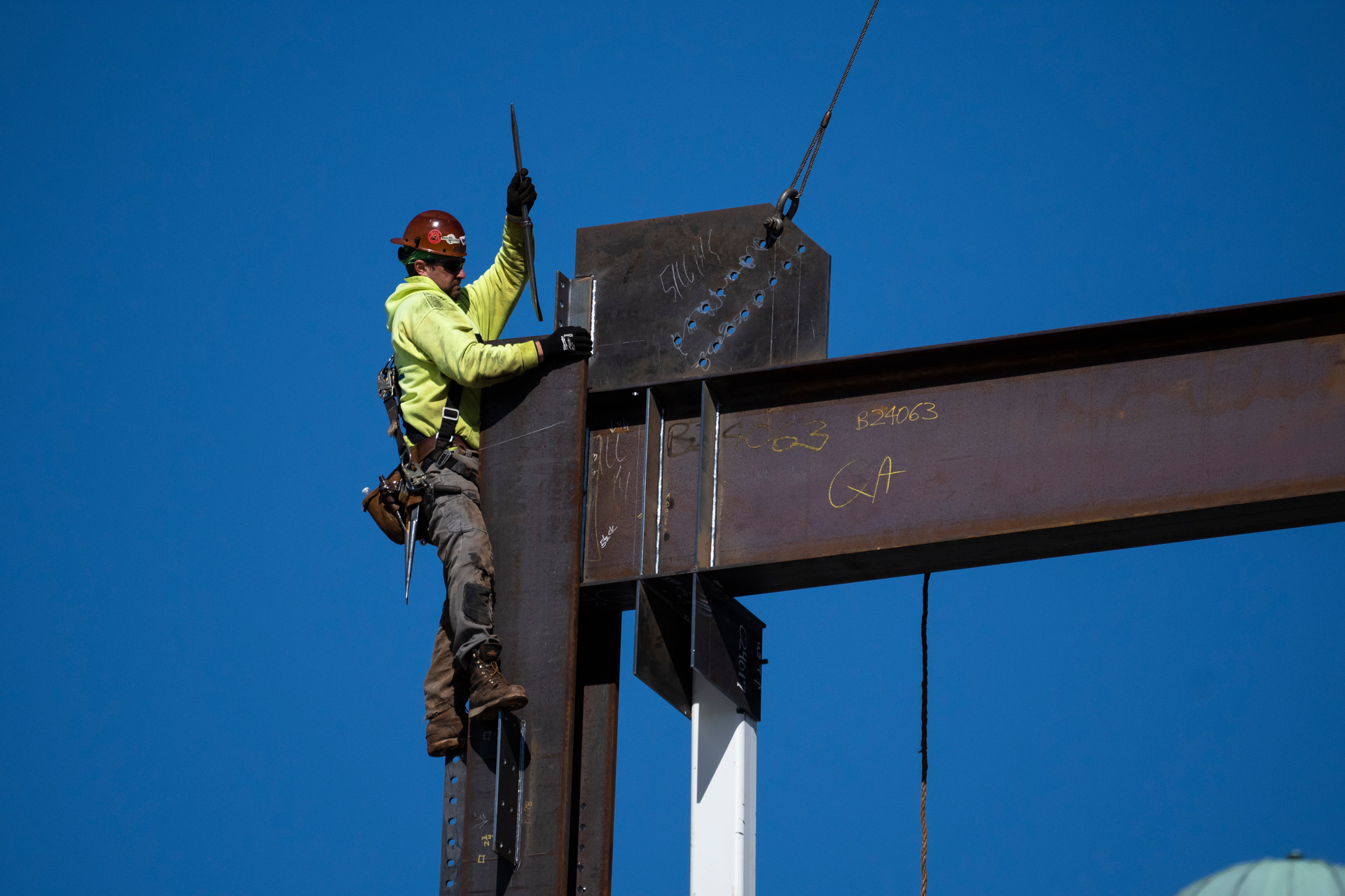 An ironworker guides a beam during construction of a municipal building in Norristown, Pa., Wednesday, Feb. 15, 2023.