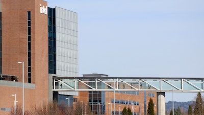 Workers walk on a skybridge to and from a large Intel facility in Hillsboro, Ore., on March 17, 2023.