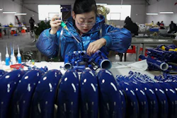 In this photo released by Xinhua News Agency, a worker assembles western musical instruments at a manufacturer factory in in Wuqiang County, north China's Hebei province on Feb. 23, 2023.
