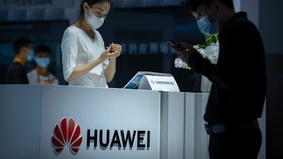 A staff member stands at a booth for Chinese technology firm Huawei at the China International Fair for Trade in Services (CIFTS) in Beijing, Friday, Sept. 3, 2021.