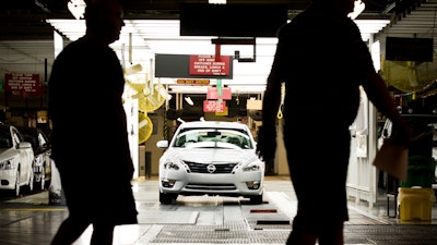 Workers at the Nissan plant in Smyrna, Tenn., walk by a Nissan Altima sedan, May 15, 2012.