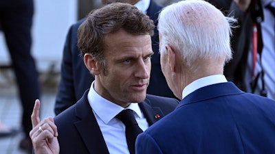 France's President Emmanuel Macron, left, speaks with U.S. President Joe Biden before a family photo of leaders of the G7 and invited countries during the G7 Leaders' Summit in Hiroshima, western Japan, Saturday, May 20, 2023.