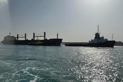 Bulk carrier ship Xin Hai Tong 23, left, is towed after it ran aground at the southern mouth of the Suez Canal, May 25, 2023.