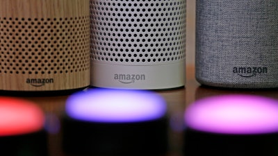Amazon Echo and Echo Plus devices, behind, sit near illuminated Echo Button devices during an event by the company in Seattle, Sept. 27, 2017.