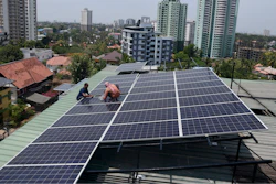 Workers install solar panels on the roof of a residential apartment in Kochi, southern Kerala state, India, March 22, 2023.