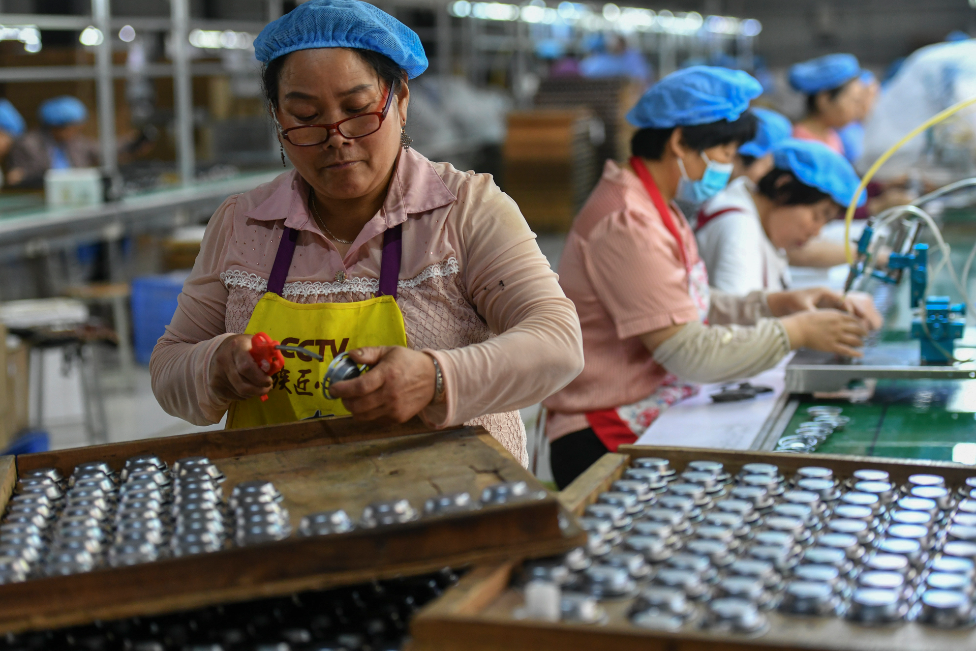 Workers assemble speakers at an electronics factory in Linquan in central China's Anhui province on May 31, 2023.