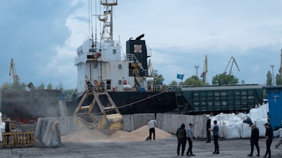 Workers load grain at a port in Izmail, Ukraine, April 26, 2023.