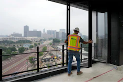 A worker opens the windows on the top floor of the new Godfrey Hotel, June 27, 2023, in Detroit.