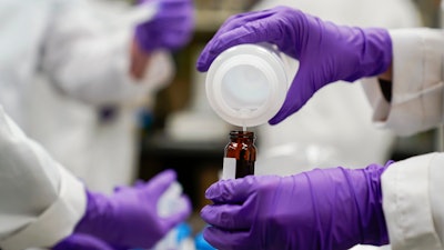 Eva Stebel, water researcher, pours a water sample at the EPA Center for Environmental Solutions and Emergency Response, Cincinnati, Feb. 16, 2023.