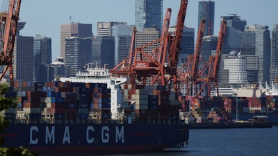 Gantry cranes sit idle as a container ship is docked at port during a work stoppage, Vancouver, July 19, 2023.