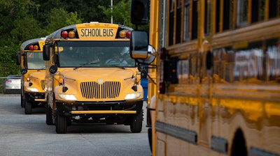 Jefferson County Public Schools buses packed with students make their way through the Detrick Bus Compound on the first day of school, Wednesday, Aug. 9, 2023, in Louisville, Ky.