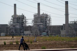 A man pushes a stroller near the AES power plant in Redondo Beach, Calif., Sept. 7, 2022.