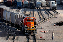 A BNSF rail terminal worker monitors the departure of a freight train, on June 15, 2021, in Galesburg, Ill.