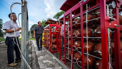 P V R Murthy, center, general manager at Oil India Limited, pump station 3, shows a part of a hydrogen plant in Jorhat, India, Thursday, Aug. 17, 2023.