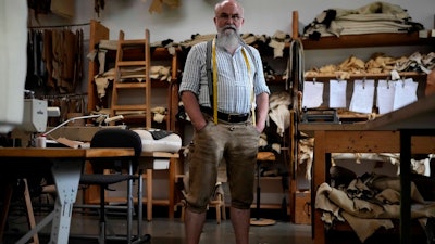 Saddler Klaus Bensmann works in his store in Bad Hindelang, Germany, Wednesday, Sept. 13, 2023. Bensmann produces tailored leather trousers and vests with hand embroidery.