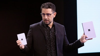 Microsoft's Chief Product Officer Panos Panay holds a Surface Duo, left, and Surface Neo at an event, Wednesday, Oct. 2, 2019, in New York.