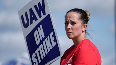 United Auto Workers member Victoria Hall walks the picket line at the Ford Michigan Assembly Plant in Wayne, Mich., Monday, Sept. 18, 2023.