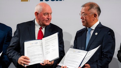 Chancellor of the University System of Georgia Sonny Perdue, left, and Hyundai Motor Group Executive Chairman Euisun Chung hold up a new memorandum of understanding for future mobility collaboration during a ceremony at Georgia Tech in Atlanta, Tuesday, Sept. 19, 2023.