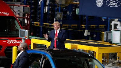 President Donald Trump claps as he walks to the podium to speak at Ford's Rawsonville Components Plant that has been converted to making personal protection and medical equipment, Thursday, May 21, 2020, in Ypsilanti, Mich.