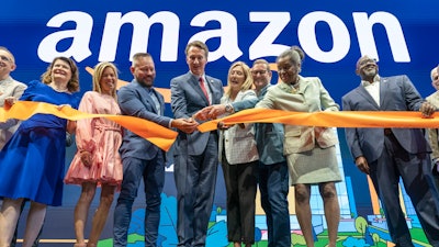 Virginia Gov. Glenn Youngkin, center, with Holly Sullivan, Vice President of Economic Development at Amazon, center right, cut the ribbon during a grand opening ceremony at Amazon's second headquarters, HQ2, in Arlington, Va., June 15, 2023.