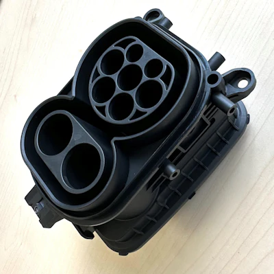 Real-world molded sample of a high-power charging inlet combo body previously tested in Moldflow software.