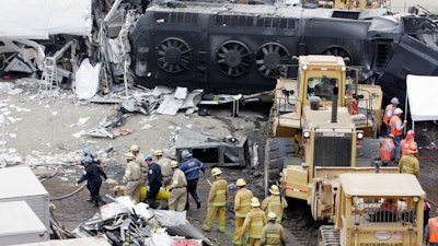 Emergency responders remove a body from the Metrolink commuter train that collided with a Union Pacific freight train the day before in Chatsworth, Calif., Sept. 13, 2008.
