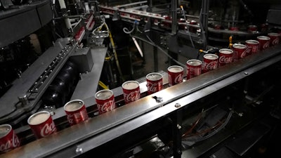 Coca-Cola cans move down a conveyer belt in the Swire Coca-Cola bottling plant Oct. 20, 2023, in Denver. Major corporations in water-guzzling industries such as apparel, food and beverage, and tech want to be better stewards of the freshwater resources they use. Coca-Cola said its water use in 2022 was about 10% more efficient compared to 2015.
