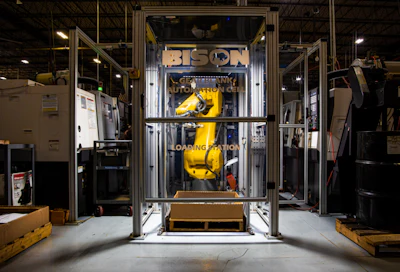FANUC robot performing gear blank finishing operation.