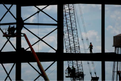 Iron workers construct the framework of a $4 billion Panasonic EV battery plant, May 18, 2023, near DeSoto, Kan.