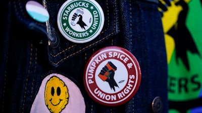 Union pins on a worker's jacket during a walkout at Starbucks' Reserve roastery, Seattle, Nov. 16, 2023.