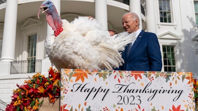 President Joe Biden stands next to Liberty, one of the two national Thanksgiving turkeys, after pardoning them on the South Lawn of the White House, Nov. 20, 2023.