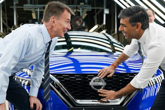 Britain's Prime Minister Rishi Sunak, right and Chancellor of the Exchequer Jeremy Hunt attach a Nissan badge to a car as they visit the car manufacturer Nissan, in Sunderland, England, Friday, Nov. 24, 2023.