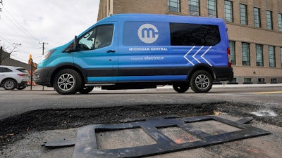 An electric van drives past a visible in-road wireless charging coil to be installed in a street in Detroit, Wednesday, Nov. 29, 2023. A demonstration of the first electric vehicle charging road in the U.S. took place Wednesday on a quarter-mile stretch of a Motor City street.