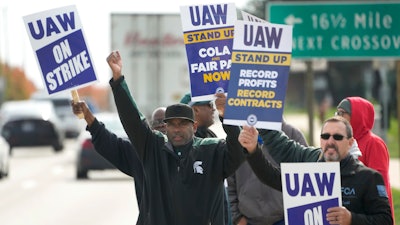 United Auto Workers members walk the picket line during a strike at the Stellantis Sterling Heights Assembly Plant, in Sterling Heights, Mich., Monday, Oct. 23, 2023. A six-week United Auto Workers strike at Ford cut sales by about 100,000 vehicles and cost the company $1.7 billion in lost profits this year, Ford said Thursday, Nov. 30, 2023.