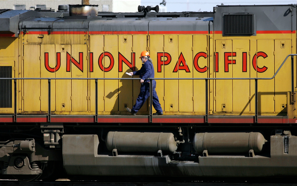 A maintenance worker walks past the company logo on the side of a locomotive in the Union Pacific Railroad fueling yard in north Denver, Oct. 18, 2006. Union Pacific announced Wednesday, Nov. 1, 2023, that it is trimming the ranks of the railroad's management employees as part of the new CEO's push to eliminate layers of bosses involved in decisions.