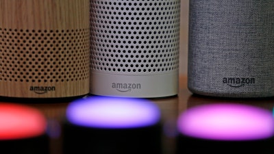 Amazon Echo and Echo Plus devices, behind, sit near illuminated Echo Button devices during an event announcing several new Amazon products by the company, Sept. 27, 2017, in Seattle.