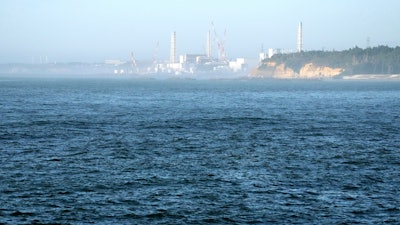 The Fukushima Daiichi nuclear power plant, damaged by a massive March 11, 2011, earthquake and tsunami, is seen from the nearby Ukedo fishing port in Namie town, northeastern Japan, on Aug. 24, 2023.