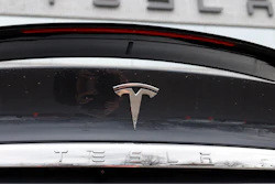 The Tesla company logo shines off the rear deck of an unsold 2020 Model X at a Tesla dealership, April 26, 2020, in Littleton, Colo.