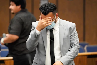 Kevin Aziz Riad shields his face as he stands in court, Aug. 15, 2023, in Compton, Calif.