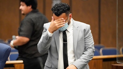 Kevin Aziz Riad shields his face as he stands in court, Aug. 15, 2023, in Compton, Calif.