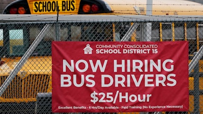 A hiring sign is displayed at a school in Palatine, Ill., Wednesday, Nov. 8, 2023. On Thursday, the Labor Department reports on the number of people who applied for unemployment benefits last week.