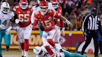 Kansas City Chiefs quarterback Patrick Mahomes (15) runs in front of Miami Dolphins defensive end Emmanuel Ogbah (91) during the first half of an NFL wild-card playoff football game Saturday, Jan. 13, 2024, in Kansas City, Mo.