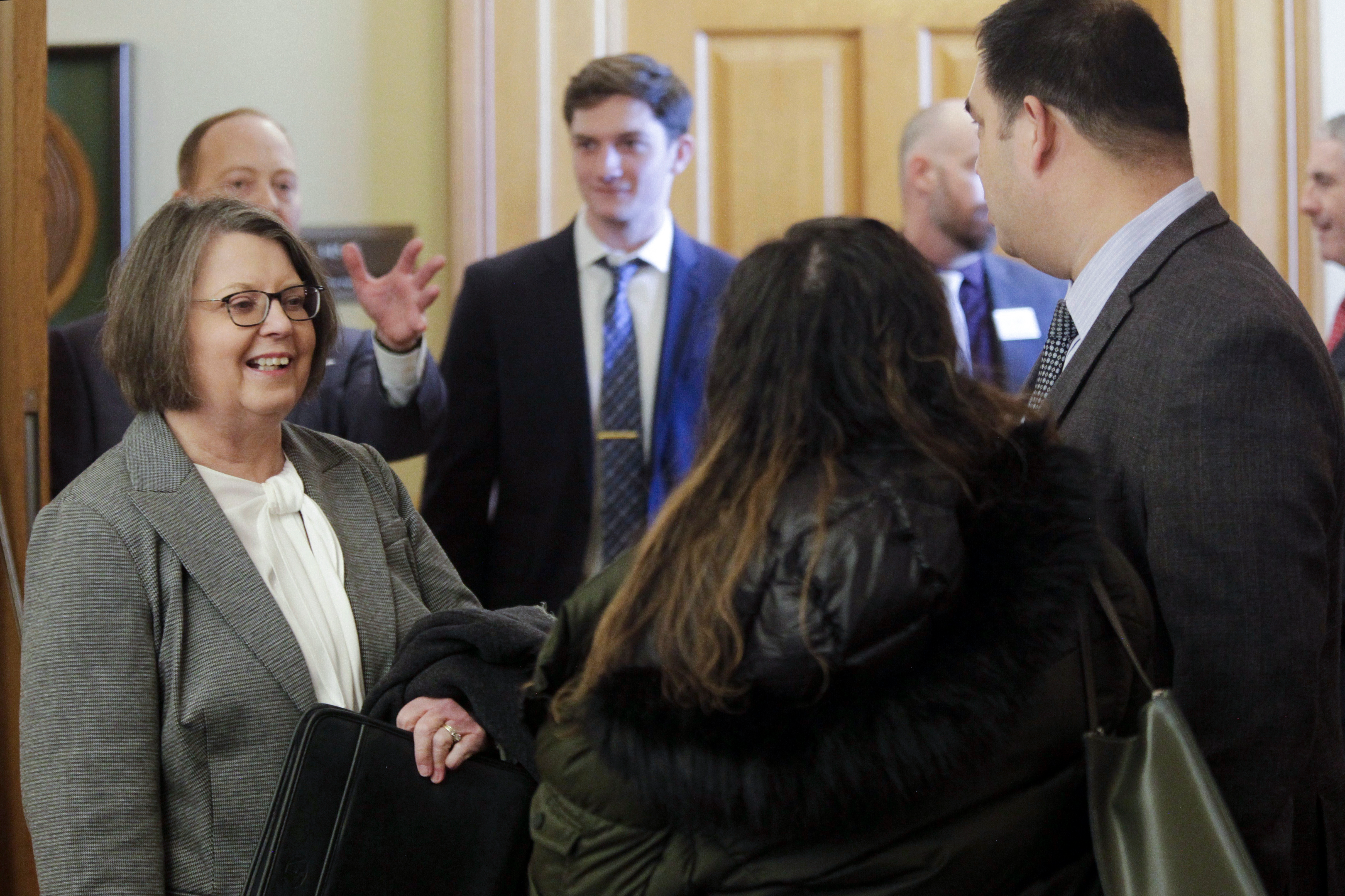Kansas Supreme Court Chief Justice Marla Luckert, left, chats with spectators who have gathered for a joint meeting of the Kansas House and Senate Judiciary committees.