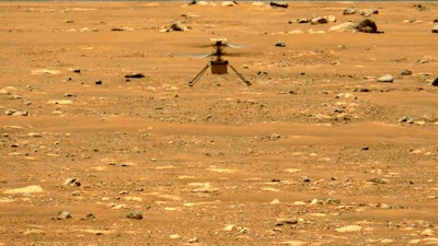 In this image made available by NASA, the Mars Ingenuity helicopter hovers above the surface of the planet during its second flight on April 22, 2021.