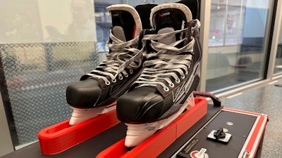 Skates sit in a Conicity Technologies’ grinding machine designed to remove tiny burrs from the metal blades, at the Washington Capitals NHL hockey team practice facility in Arlington, Virginia, Nov. 28, 2023.
