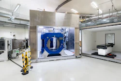 Beam line of the proton therapy system (left) with opened Aurora-PT system (i.e. in-beam MRI (middle) and patient couch (right).