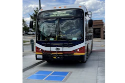 Municipal bus approaching a wireless inductive charging pad.