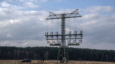 Police officers work next to a damaged pylon near the Tesla Gigafactory for electric cars in Gruenheide near Berlin, Germany, on March 5, 2024.